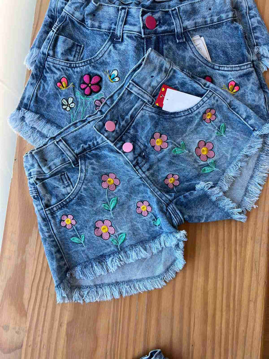 SHORT JEANS COM AJUSTE BARRA DESFIADA MARGARIDAS BORDADAS MENINA LUI BAMBINI