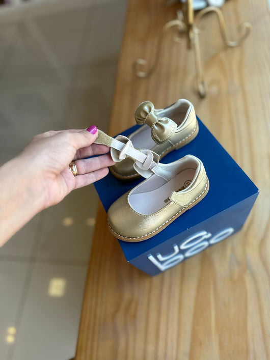 SAPATO DOURADO COM VELCRO PÉROLA STRASS E LAÇO REMOVÍVEL MENINA XUA XUA